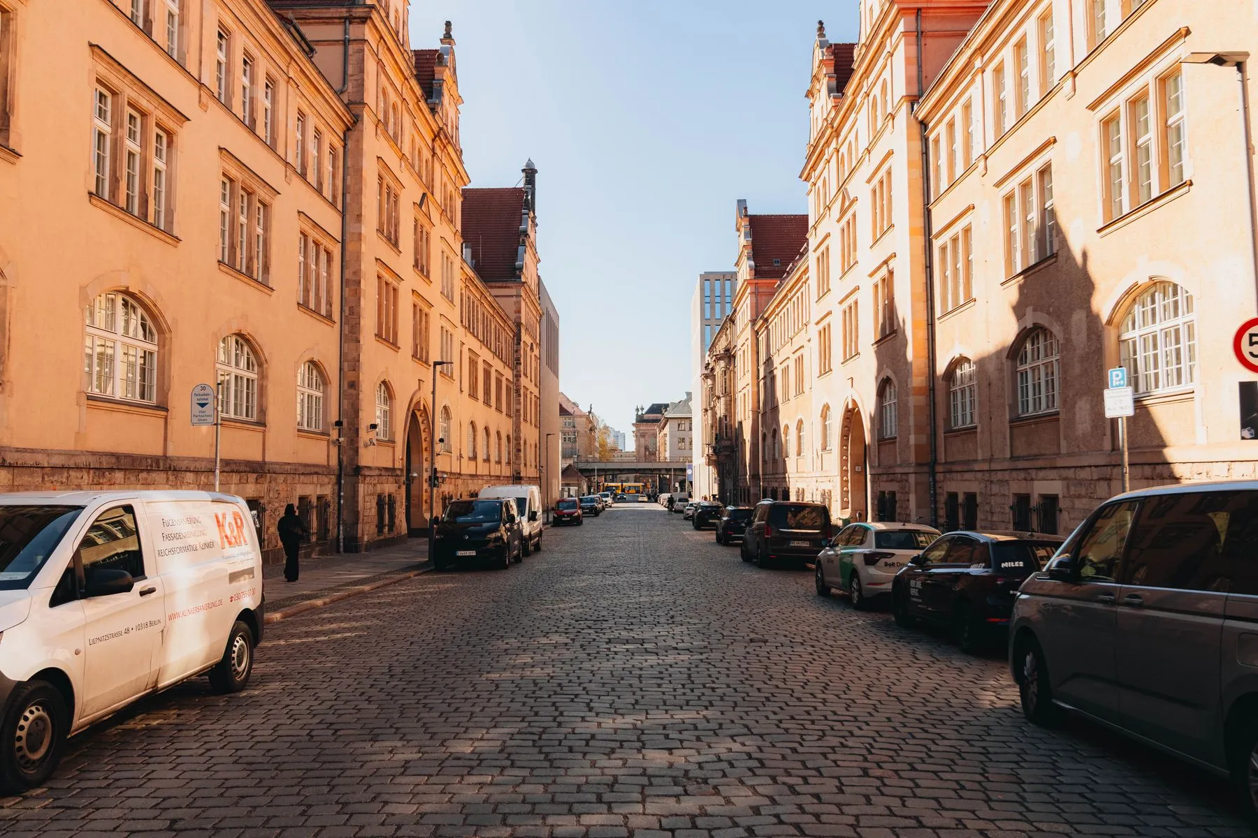 A warm, cobblestoned Berlin street in golden light