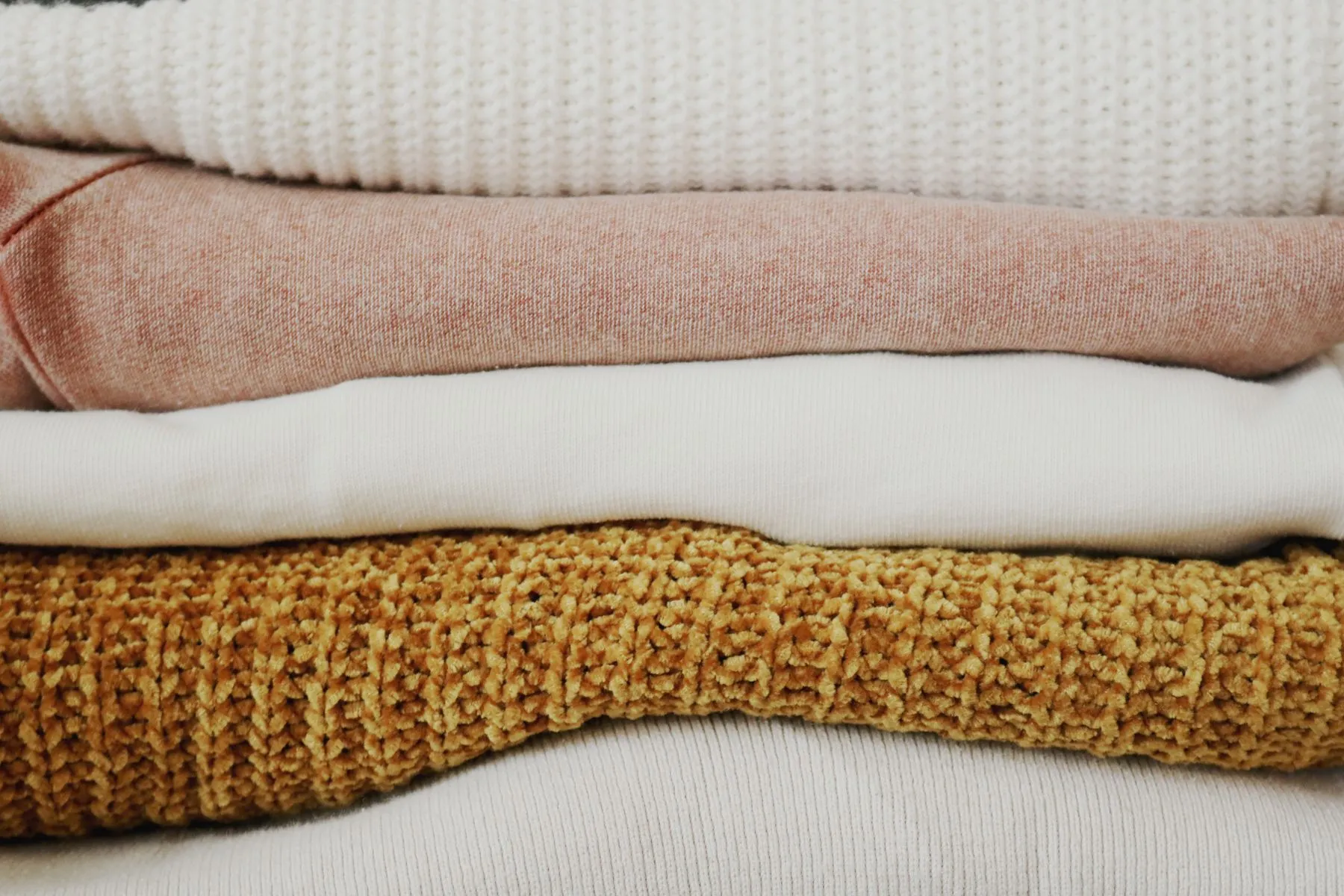 Neatly folded linens in warm, quiet household tones