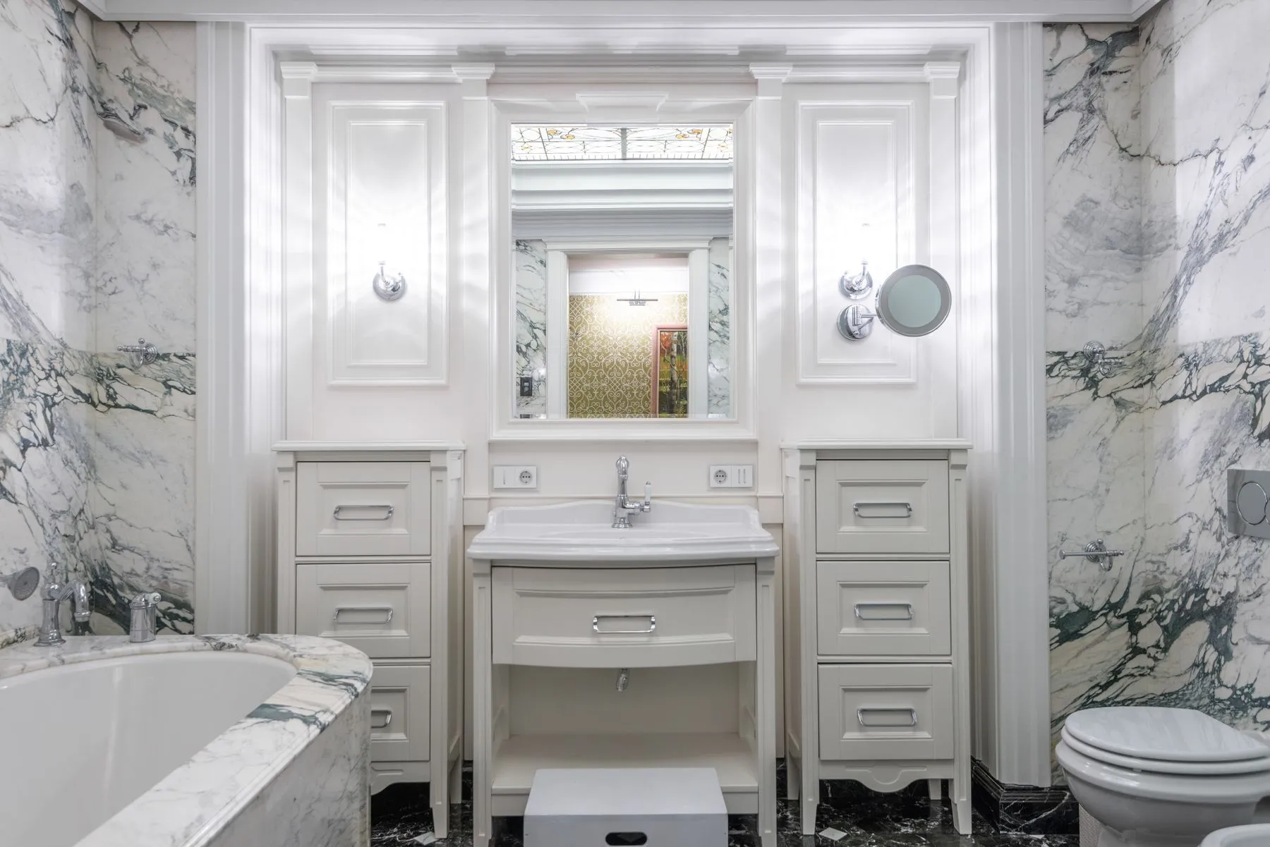 A refined white-marble hotel bathroom