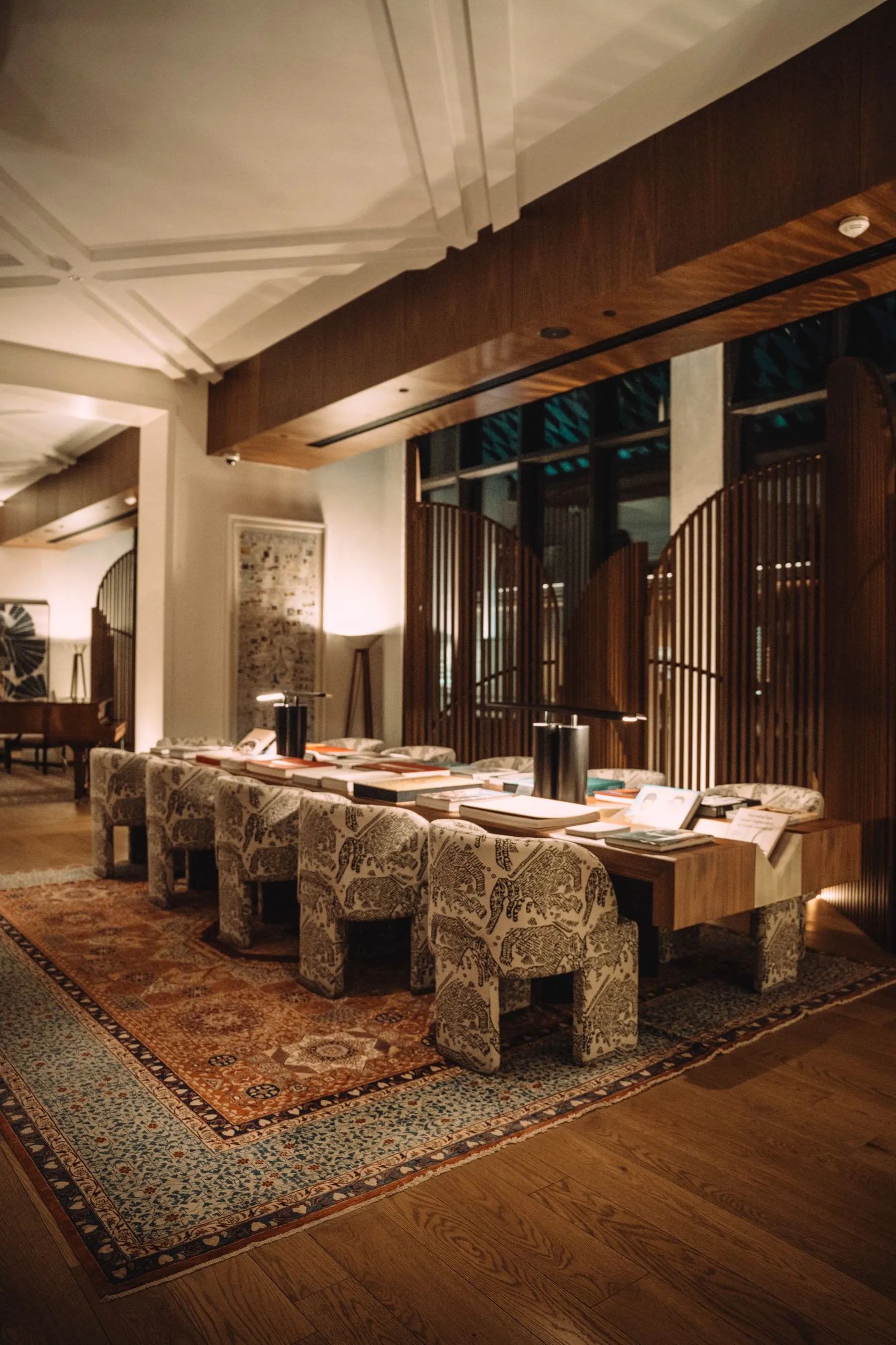 A quiet, warm hotel reading lounge with walnut panelling
