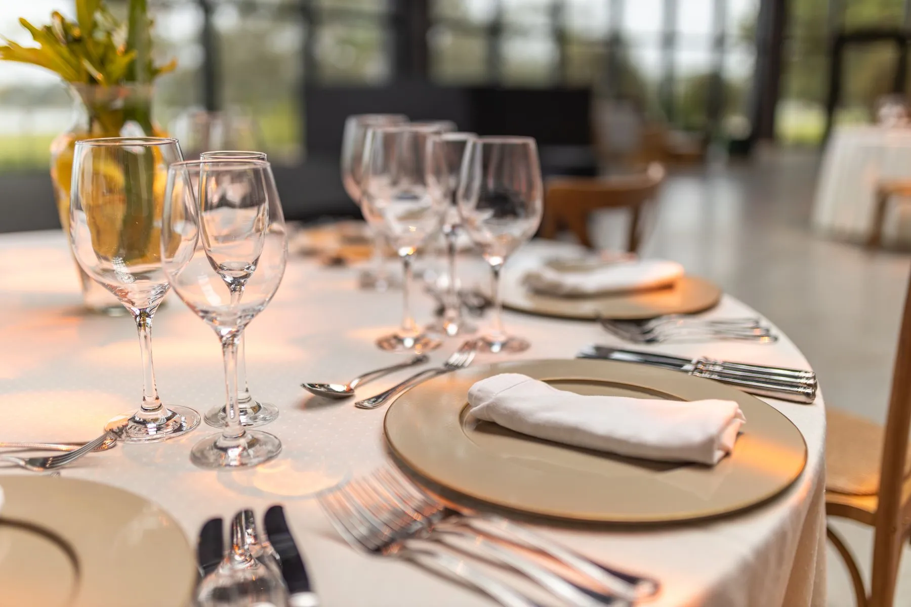 An elegantly set restaurant table with linen and glassware
